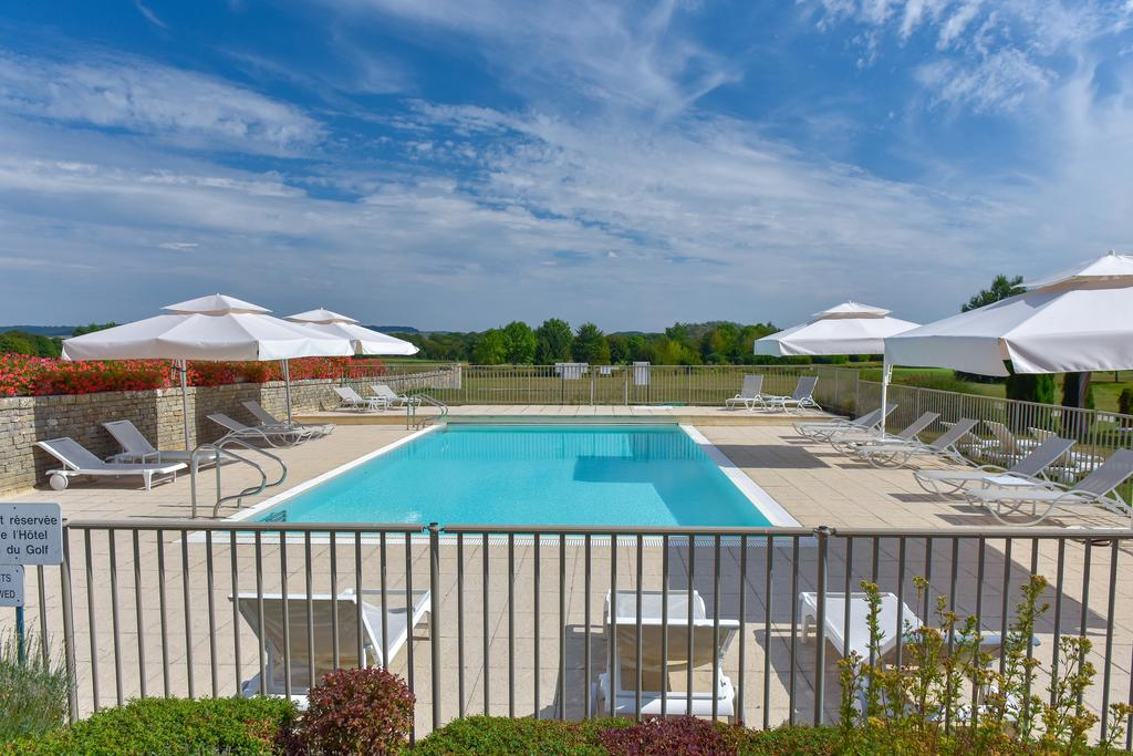 Outdoor pool at Château de Chailly with white parasols
