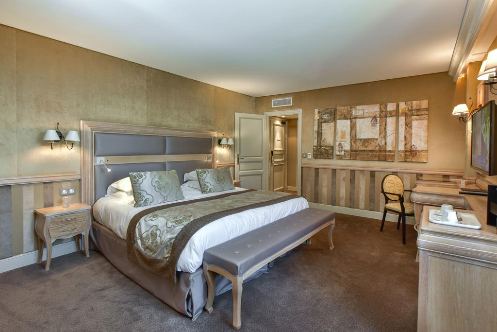 Classic bedroom at Château de Chailly with neutral walls and upholstered bench