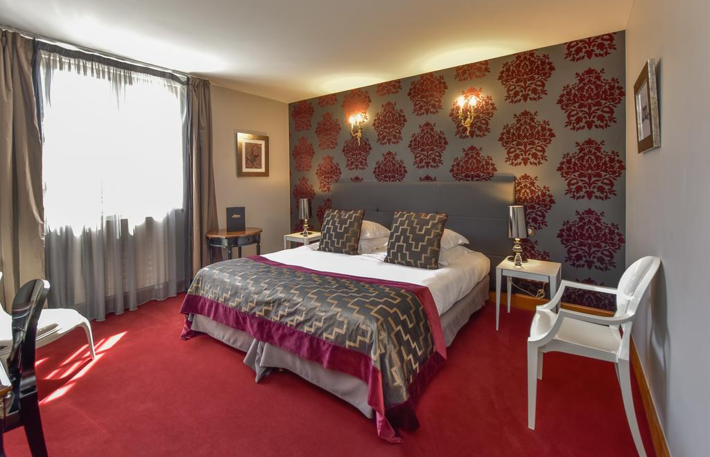 Double bedroom at Château de Chailly with red carpet and patterned headboard wall