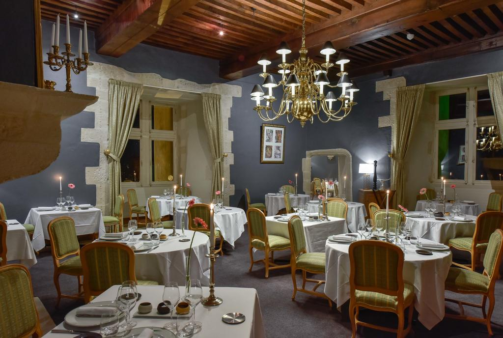 Formal restaurant at Château de Chailly with chandelier and timber ceiling