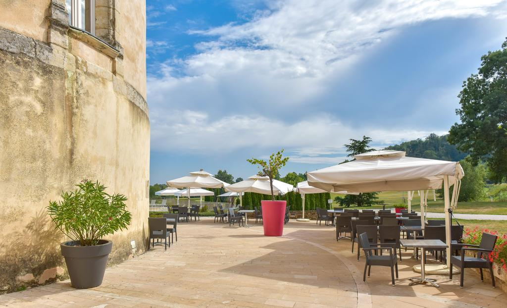 Stone terrace at Château de Chailly with café tables and parasols
