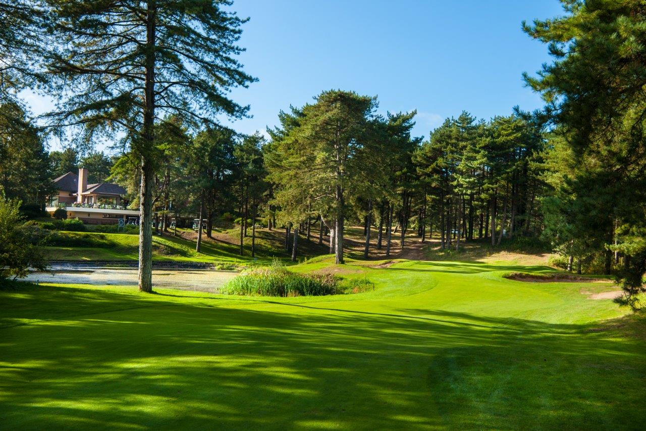 The clubhouse through the trees on Hardelot Les Dunes golf course, France