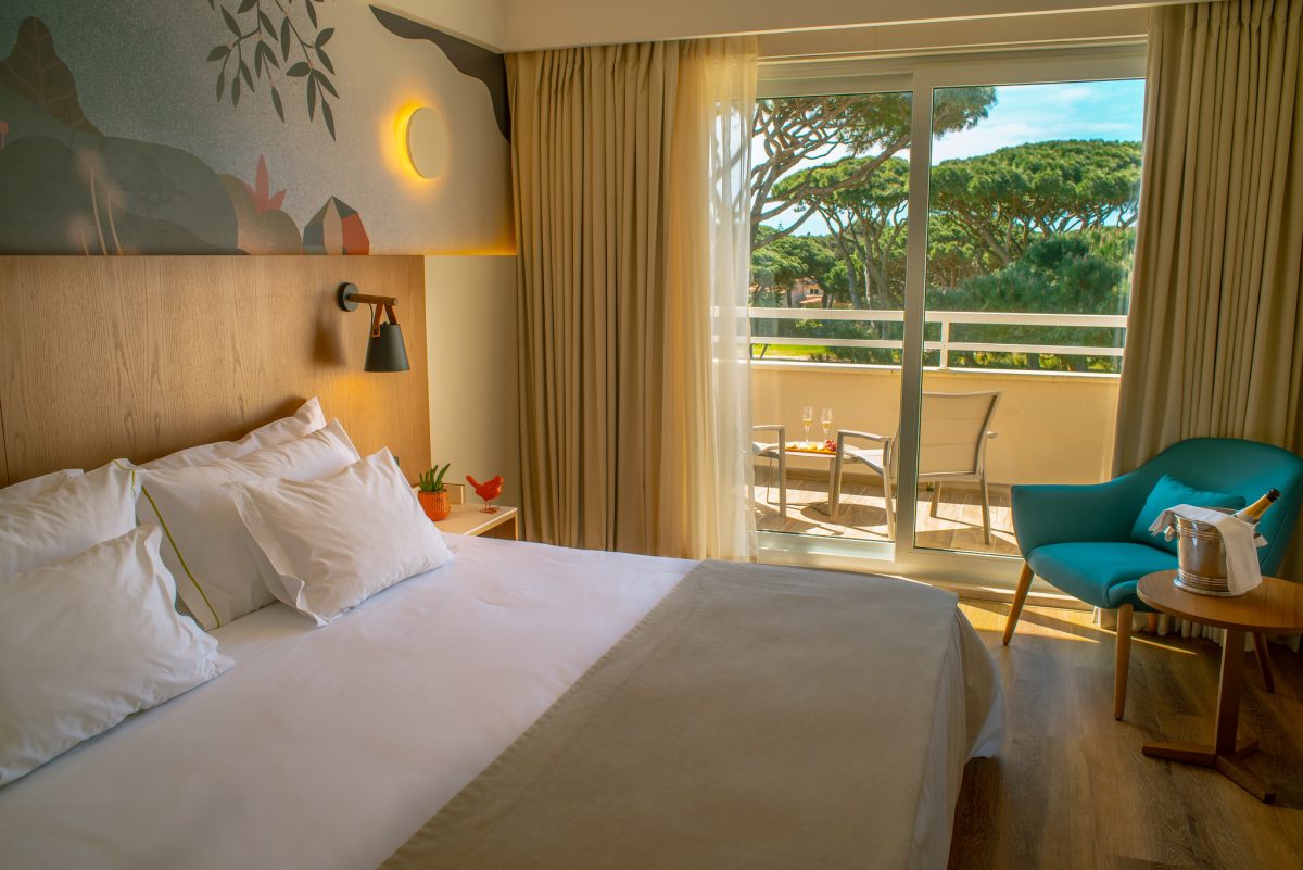 Double bedroom with seated area and balcony at Onyria Quinta da Marinha Resort, Cascais, Portugal