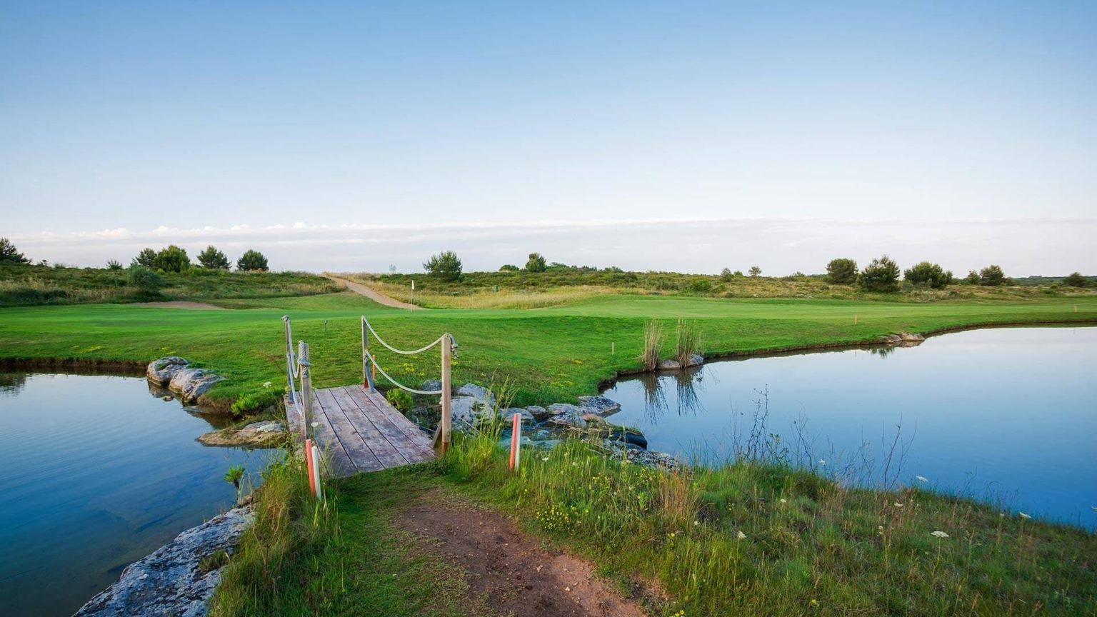 A green and water hazard on the course at Acaya Golf Club