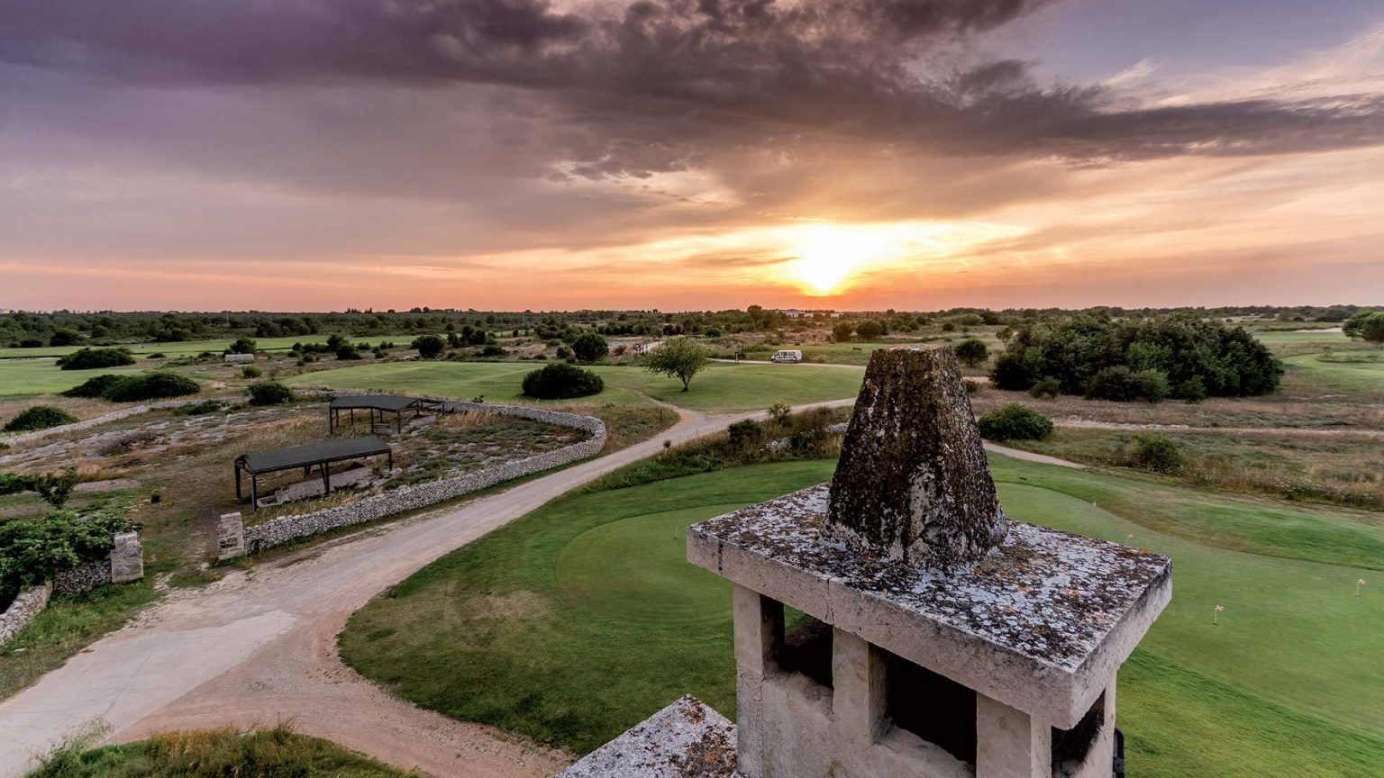 The Acaya golf course at sunset with a traditional Puglian stone trullo