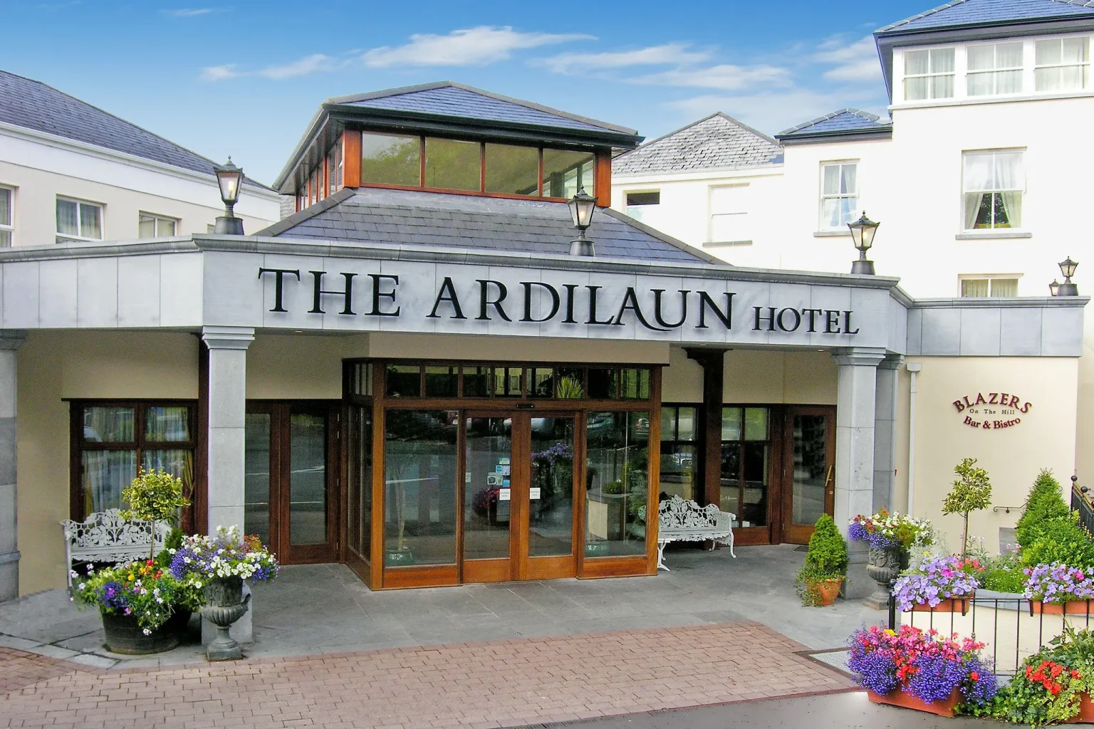 The front entrance and period facade of The Ardilaun Hotel in Galway, with floral frontage