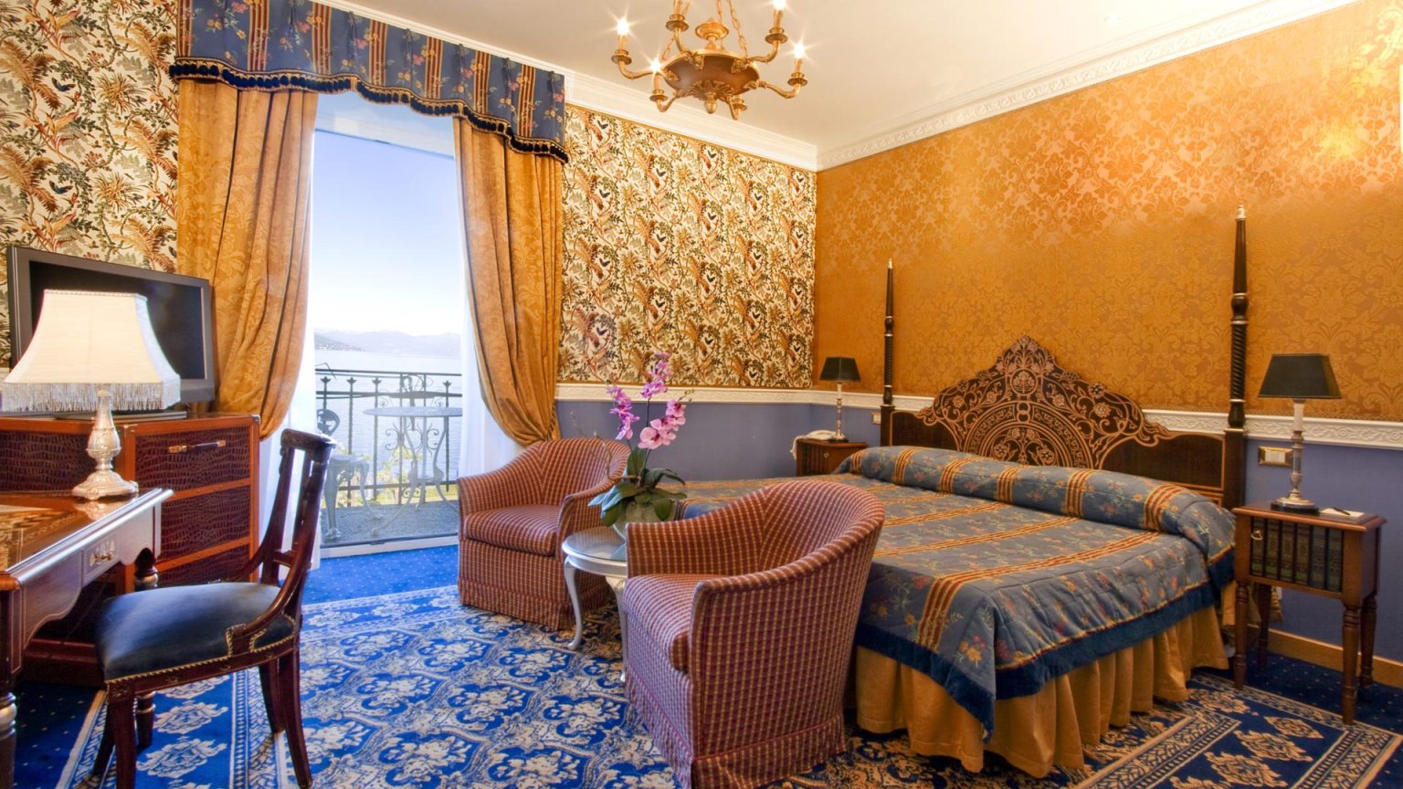 A classic lake-view guest room at Borromees in blue and gold, with a balcony onto Lake Maggiore