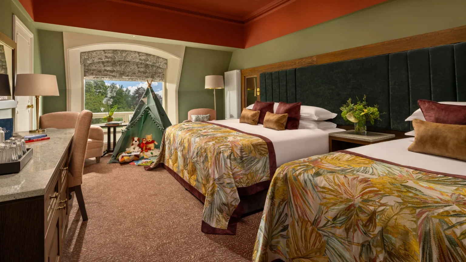 A family room at Culloden Estate and Spa with twin beds and a terracotta ceiling