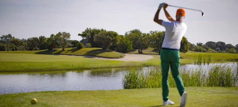 A golfer playing over the water on the Is Molas course in southern Sardinia