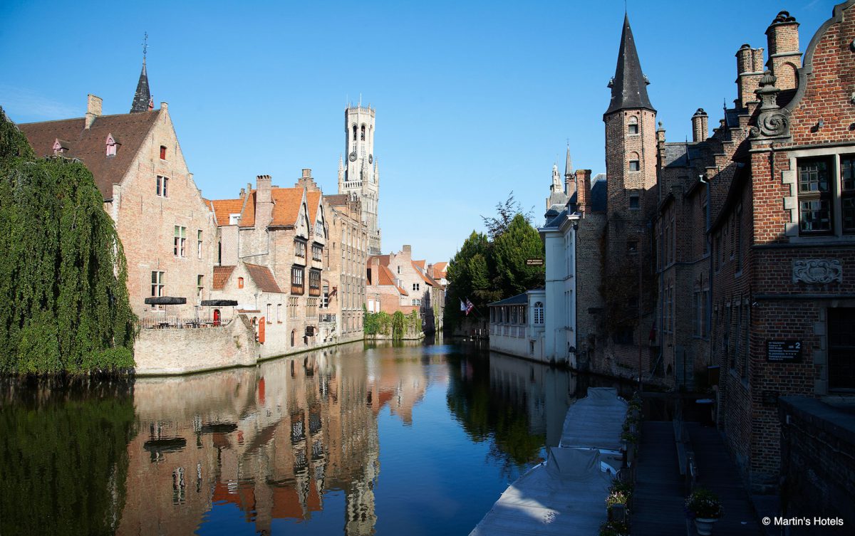 The canal runs past Martin's Relais Hotel, Bruges, Belgium