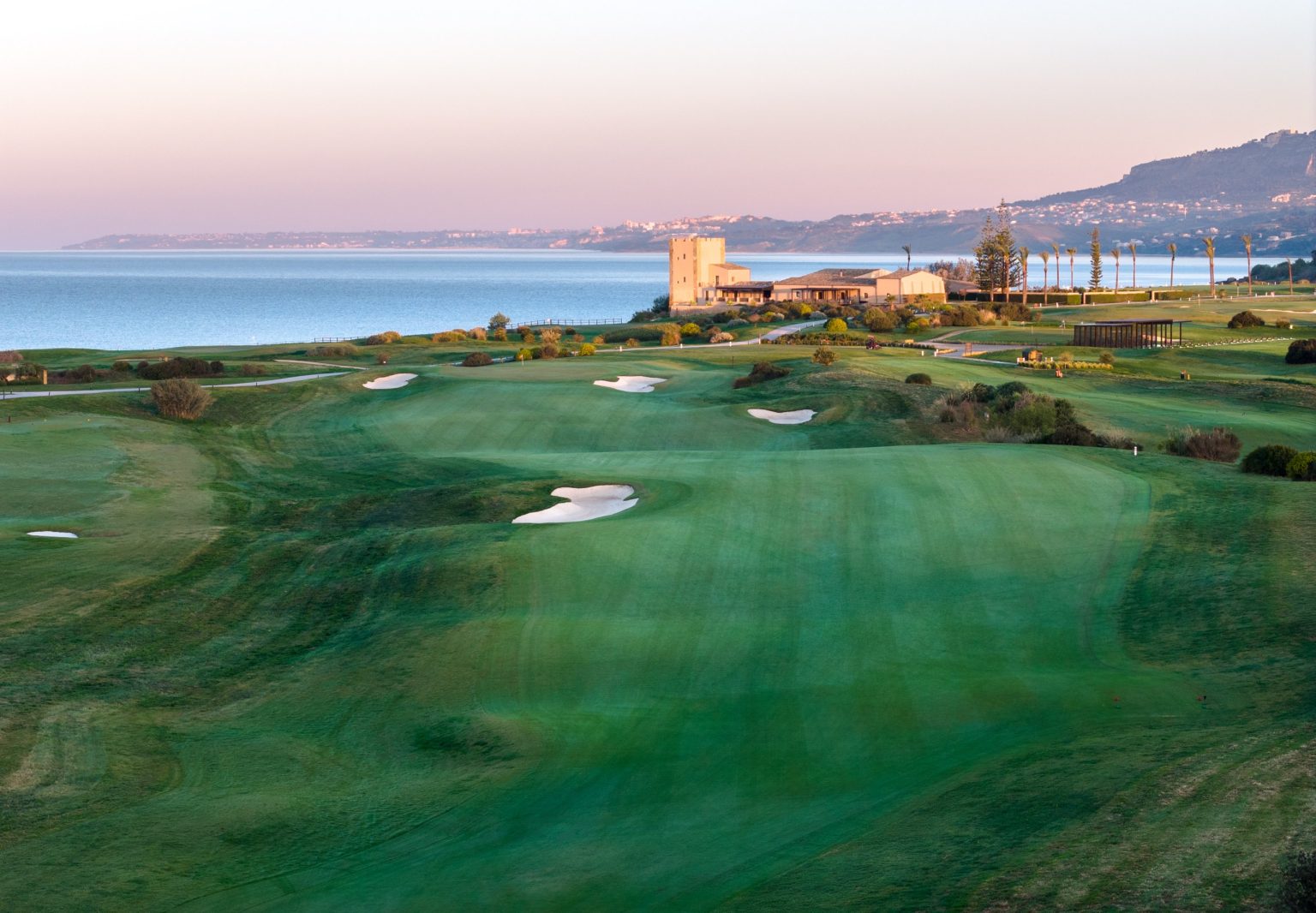 Aerial view of Verdura Resort and its coastal golf course at dusk