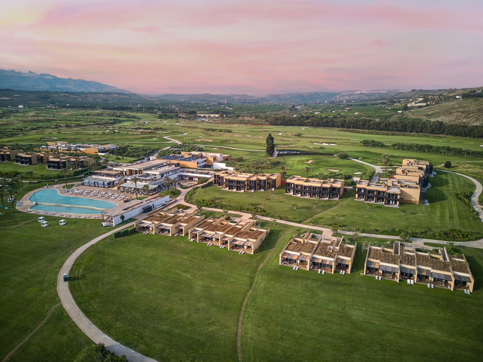 Aerial view of Verdura Resort and its golf courses along the Sicilian coast at sunset