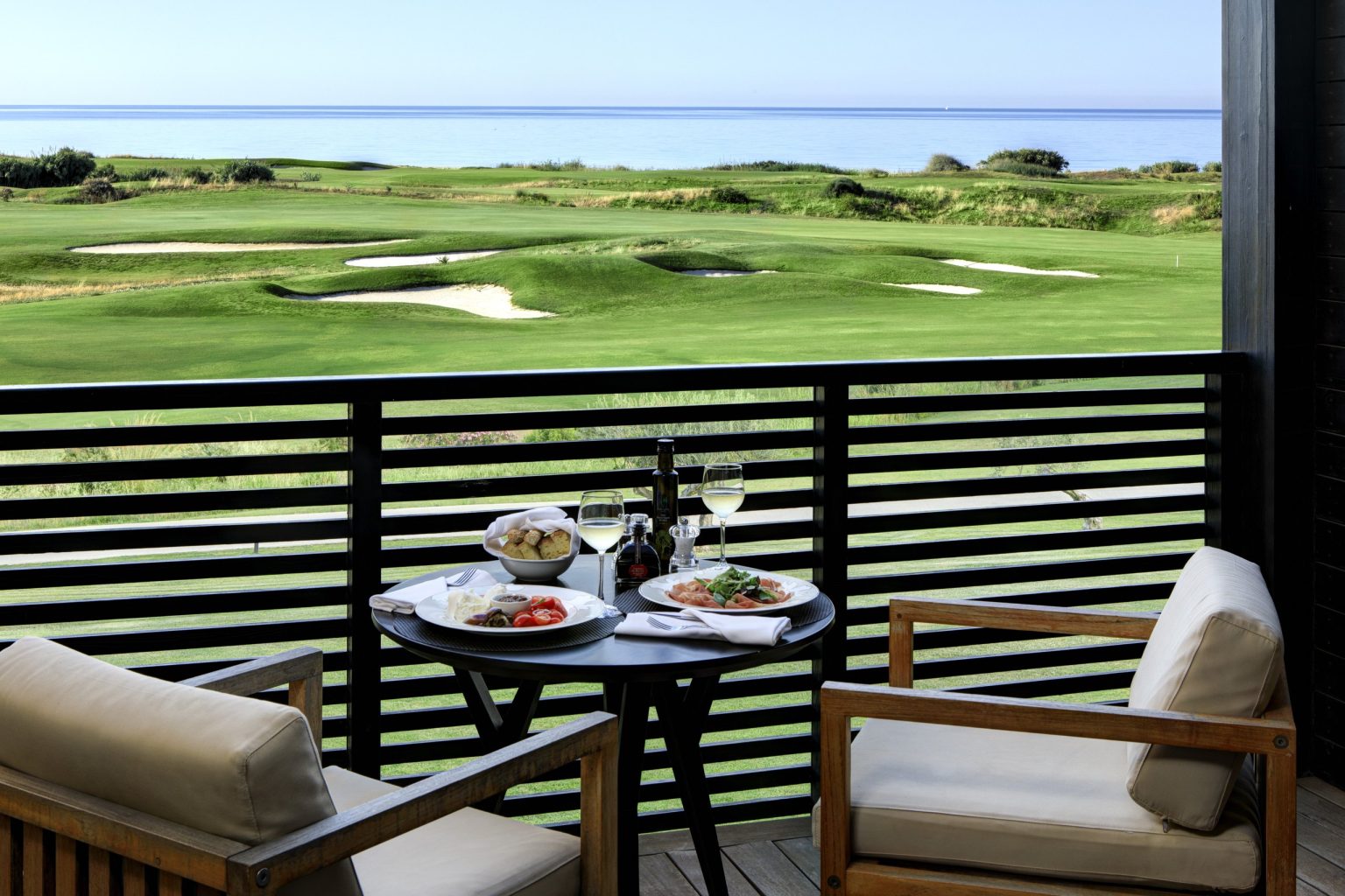 A deluxe room's private terrace at Verdura Resort, looking out to the golf and the sea