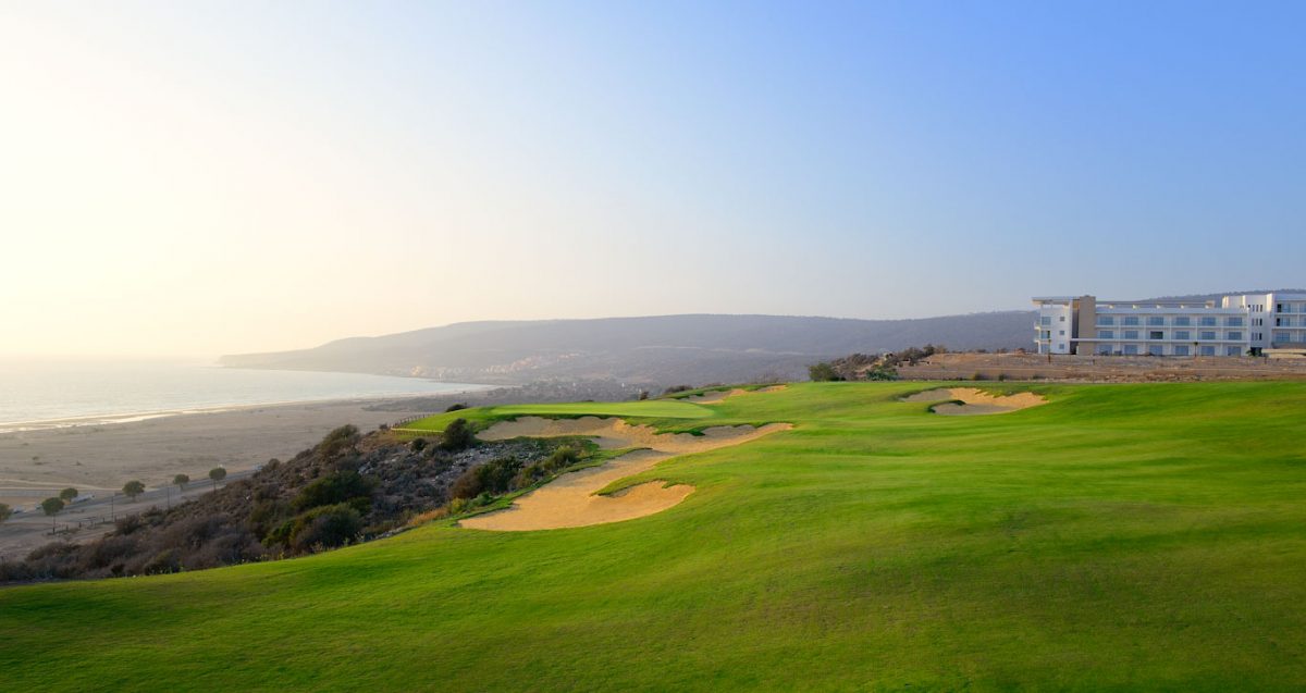 The 18th green at Tazegzout golf course and the Hyatt Place Taghazout Bay Hotel, Agadir, Morocco