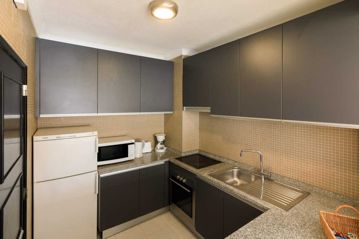 A modern kitchen with oven, fridge and microwave in your accommodation at Vale do Lobo Resort