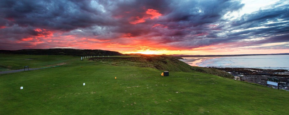 The sun sinks over the sea at Bamburgh Castle Golf club, Northumberland, England