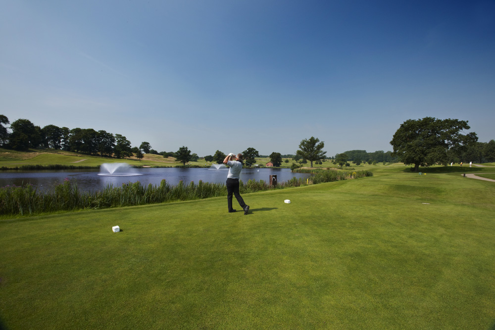 Tee off over the water on the 8th at the King's Course The Warwickshire Golf and Country Club