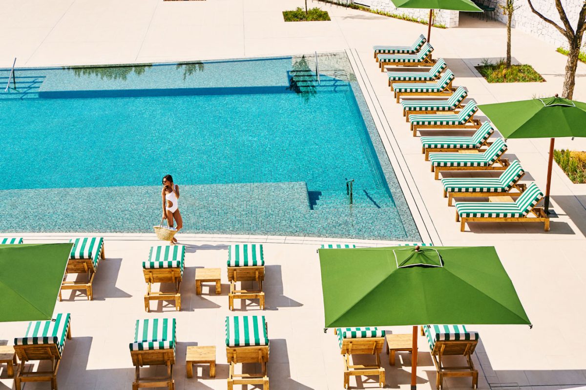 The large swimming pool at Hotel Camiral PGA Catalunya Golf Resort is surrounded by comfortable sun loungers