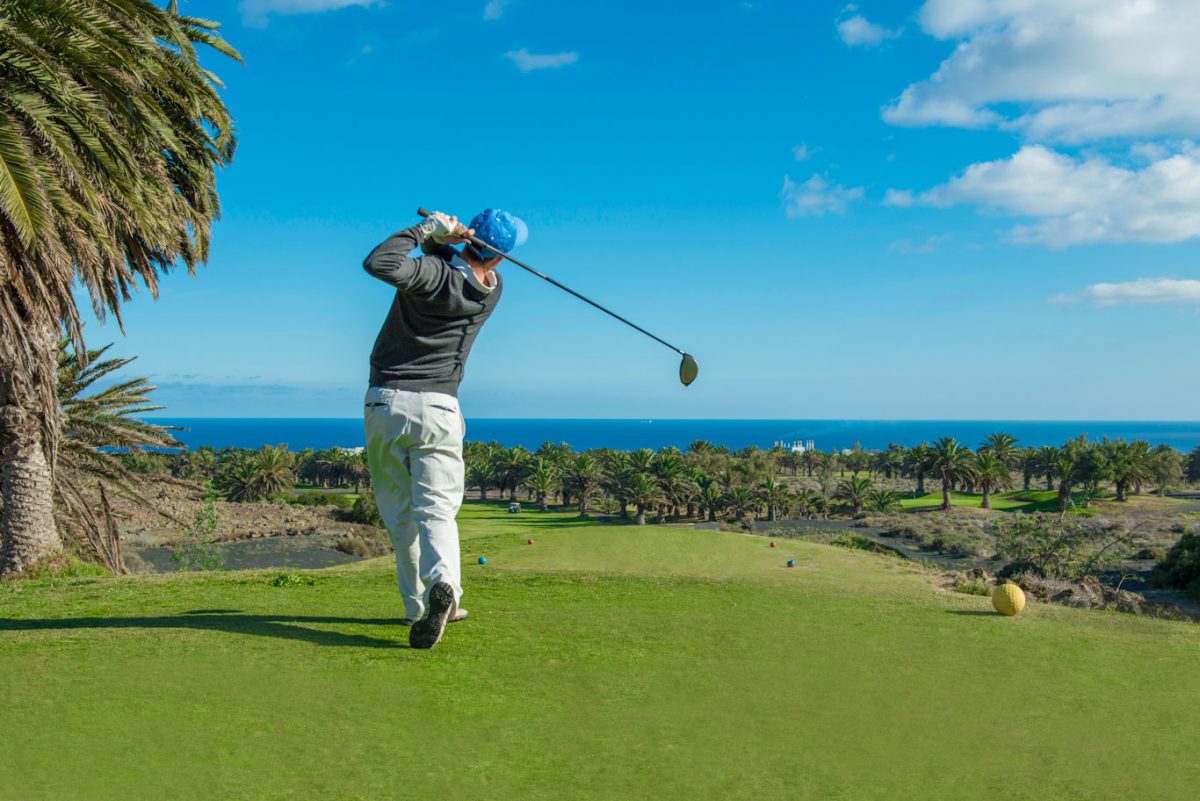 Golfer teeing off at Lanzarote Golf club, Canary Islands