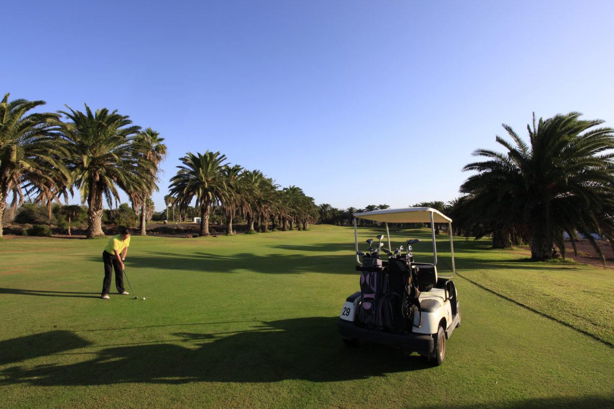 Golfer about to hit a ball at Lanzarote Golf Club, Canary Islands