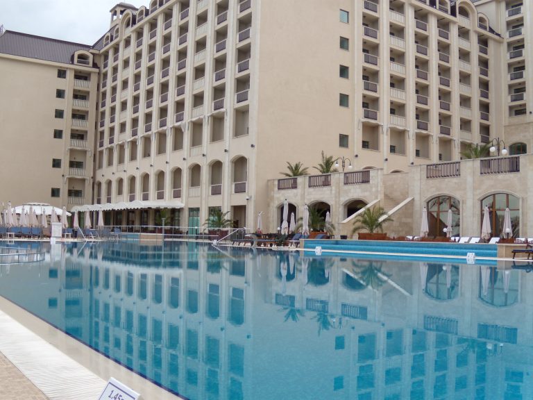 The cream arched facade of Melia Grand Hermitage at Golden Sands, mirrored in the large outdoor pool
